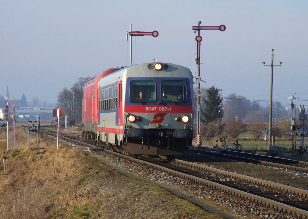 5047 087 (mit einer planmäßig angehängten 2016) trifft als R 5824 Braunau am Inn - Steindorf bei Straßwalchen im Bahnhof Munderfing ein, welcher in Ri. Braunau noch mit Formsignalen ausgestattet ist. [03.02.14]