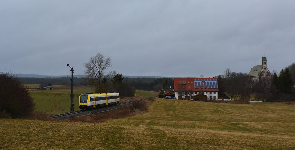 612 005 fährt bei Regen als RE26390 nach Villigen am Einfahrsignal von Löffingen vorbei. Rechts im Bild ist die Wallfahrtskapelle Witterschneekreuz zu sehen.

Löffingen 28.03.2018