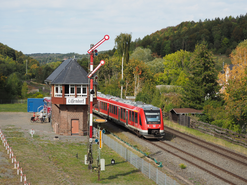 620 015 verl�sst als RB22 nach Trier den Bedarfshalt Lissendorf.
Links zu sehen ist das Museumsstellwerk samt den zwar bedienbaren, aber au�er Betrieb befindlichen Vor- und Hauptsignal. Im Hintergrund leicht angerissen ist auch ein Uerdinger Schienenbus auf einem Stummelgleis.

Lissendorf, der 26.09.2026