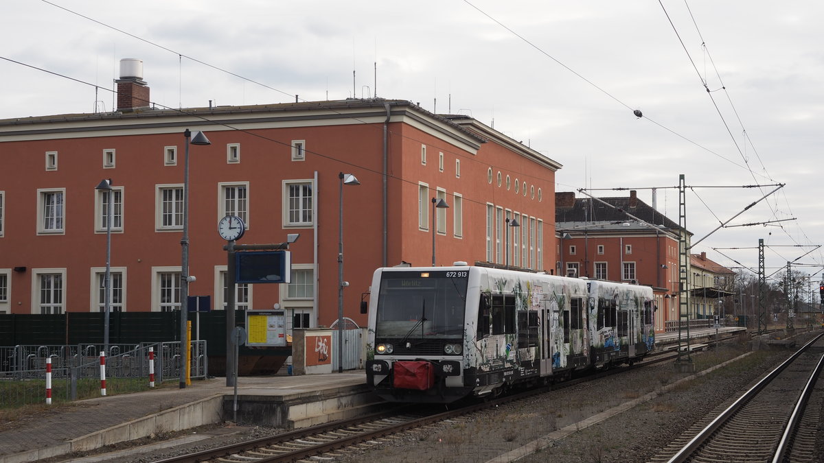 672 913 (führend) fährt zusammen mit 672 915 als DWE 27777 an ihrem ersten Saisonag des Jahres 2021 von Dessau nach Wörlitz, hier im Startbahnhof Dessau Hauptbahnhof, Gleis 1.
Leider spielte das Wetter nicht ganz mit, aber so erkennt man das nicht-funktionierende Spitzensignal links unten. 

Dessau, der 20.03.2021