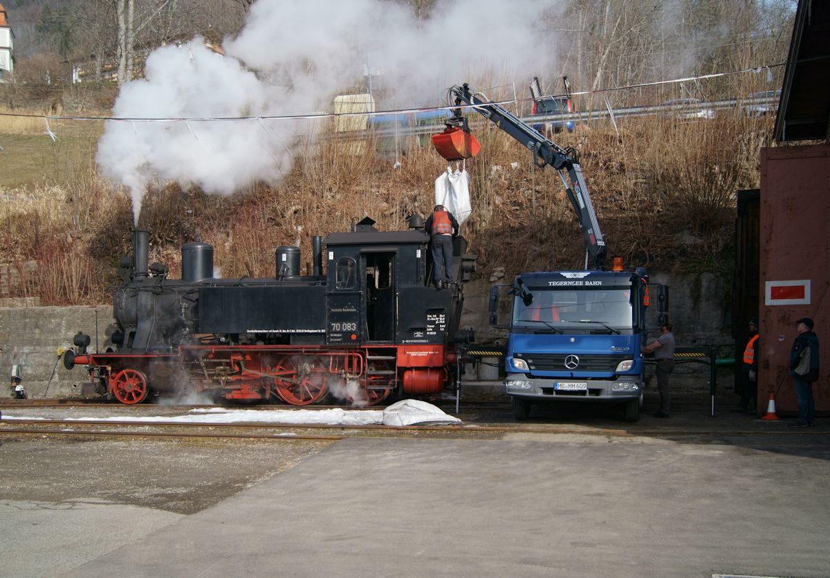 70 083 war am 12.02.2017 mit einem Dampfzug zwischen Tegernsee und Holzkirchen unterwegs. Hier wird sie im Betriebswerk der Tegernseebahn, mit einem interessanten Verfahren, gerade frisch bekohlt.