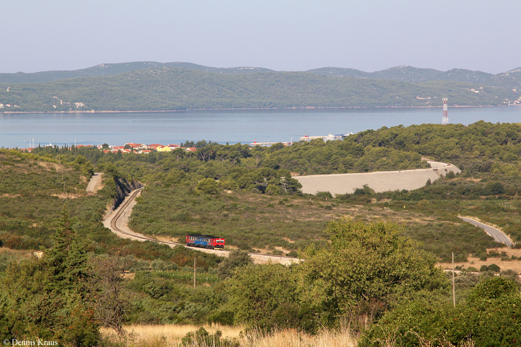 7122 013 ist am 31.08.2013 als 5700 auf dem Weg von Zadar nach Knin. Die Aufnahme entstand in Debeljak. Im Hintergrund ist die Insel Pasman zu sehen, dazwischen die Adria.
