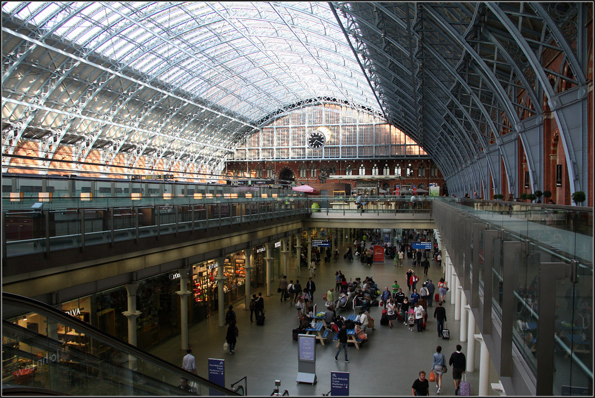 74 Meter breite Bögen -

1868 war die Bogenkonstruktion der Bahnsteighalle des Londoner Bahnhofes St. Pancras mit 74 Meter die größte Konstruktion dieser Art weltweit. So konnte die Bahnsteighalle ganz ohne störende Stützen auskommen.

Heute befinden sich die sechs Gleise für den Eurostar innerhalb dieser Halle. Die anderen Züge enden weiter hinten rechts und links neben den internationalen Gleisen in einer neuen Bahnsteighalle mit flachem Dach. Die Wege von dort zu den Underground-Zügen sind entsprechend weiter. Auf der Westseite des Bahnhofes gibt es noch zwei unterirdische Gleise für die Thameslink-Züge. Dieser Neubau des Jahres 2007 ersetzt den Bahnhof King's Cross der Thameslink.

Unter den Gleisen des Eurostars befinden sich die Bereiche zum Einchecken in diese Züge, mit Sicherheits- und Passkontrollen ähnlich wie auf einem Flughafen. Der Zeitvorteil durch die Schnellstrecke geht dadurch wieder verloren, da man 45 Minuten vor Abfahrt am Bahnhof sein soll.

28.06.2015 (Matthias)