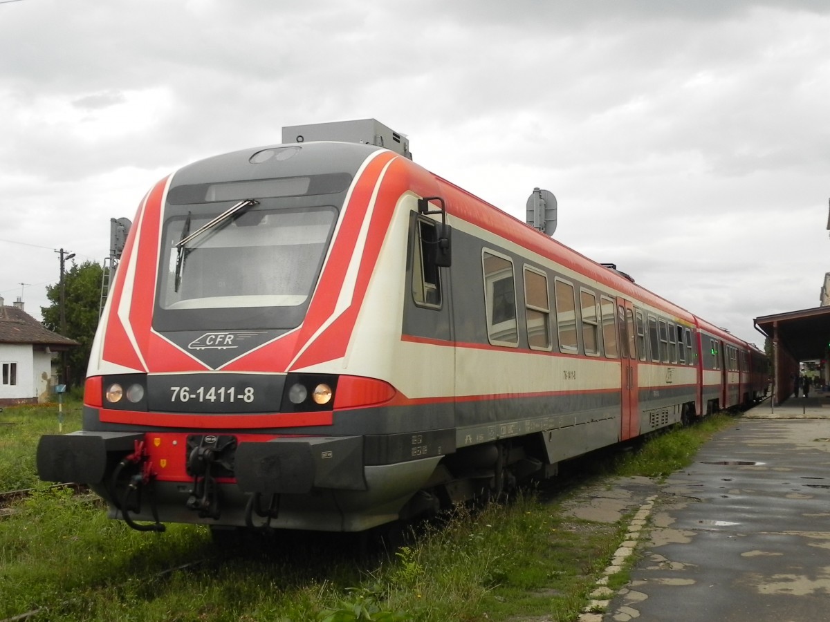 76-1411-8 verlsst am 28.08.2013 um 10:04 Uhr den Bahnhof Sibiu vom Gleis 1. Die Baureihe  76  sind umgebaute  614  der DB und gelangten ber einen Zwischenhndler nach Rumnien, wo ich sie, eingesetzt von der CFR in Sibiu umd Oradea gesehen habe. Die Inneneinrichtung unterscheidet sich nur durch andere Sitzbezge von Baureihe 614 und auch die Motoren sind, zumindest dem Klang nach zu urteilen, noch die Originalen. 