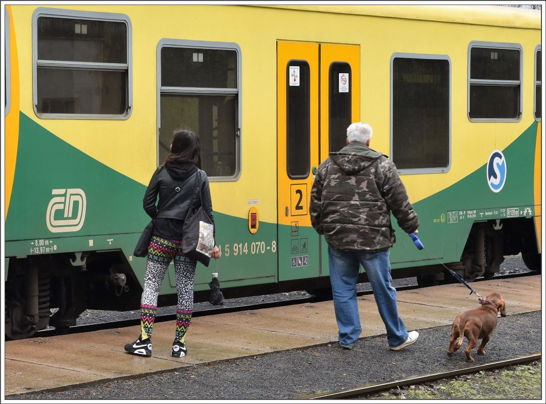 814/914 070-8 in Úštěk. So bunt wie die Züge sind auch die wartenden Passagiere gekleidet. (07.04.2017)