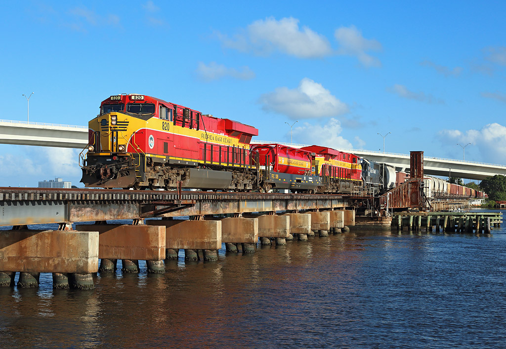 820 & 823 cross the St Lucie River in Stuart whilst hauling FEC202-20 from Miami to Jacksonville, 20 February 2019.

GP40-2 number 432 is being hauled dead in the consist...