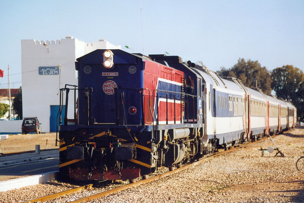 91 91 0000 565-2 (040-GT-565) (Bo'Bo', de, Hersteller: EMD, Type: GT18B, Fab.Nr.: 938830-15, Baujahr 1999) am 27.Dezember 2001 mit dem DC 5-12/53 (DC=Direct Climatise / 5=Linie Tunis Ville - Sfax / 12=Linie Sfax - Gabes / 53=Zugnummer) im Gare de El Jem. (Fotoscan)
