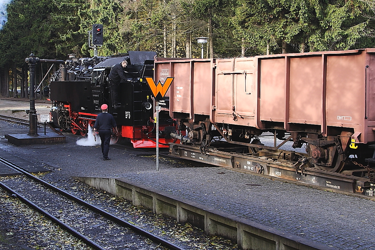 99 222 vor dem Foto-Güterzug der HSB am Vormittag des 19.10.2013 beim Wasserfassen im Bahnhof Drei Annen Hohne. Bevor es weitergeht, gibt es noch eine kurze Absprache zwischen Lokpersonal und Fahrdienstleiter. Die Aufnahme entstand aus dem ausfahrenden Sonderzug der IG HSB in Richtung  Eisfelder Talmühle , für welchen der Güterzug als Fotokulisse heute im Einsatz war.