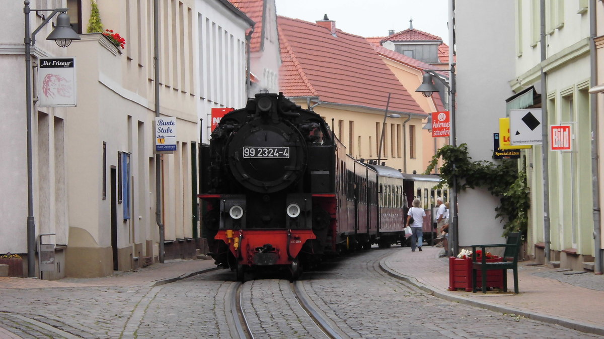 99 2324 der Mecklenburgischen Bäderbahn ,,Molli'' bei einer Ortsdurchfahrt durch Bad Doberan. Aufgenommen im August 2015.