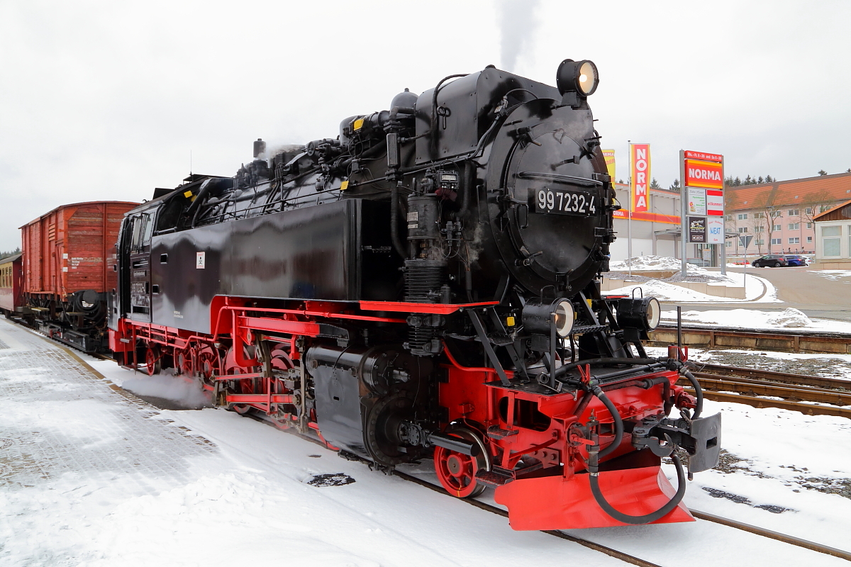 99 7232 hat am Vormittag des 25.02.2017 mit ihrem IG HSB-Sonder-PmG (Wernigerode-Hasselfelde) soeben den Bahnhof Benneckenstein erreicht. Hier wird jetzt wieder Wasser genommen und die Kreuzung mit einem Plan-Triebwagen abgewartet.