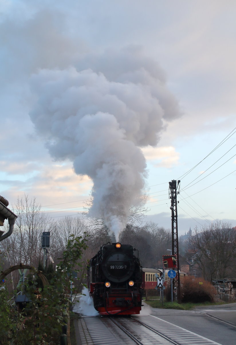 99 7235-7 beschleunigt aus der ehemaligen Station  Kirchstraße , die jetzt Wernigerode Hochschule Harz heißt, heraus und fährt nun ein kleines Stück als Straßenabhn. Wer genau hinschaut kann das Schloss Wernigerode neben dem Masten rechts sehen.

Wernigerode Hochschule Harz, 18. Dezemebr 2016,