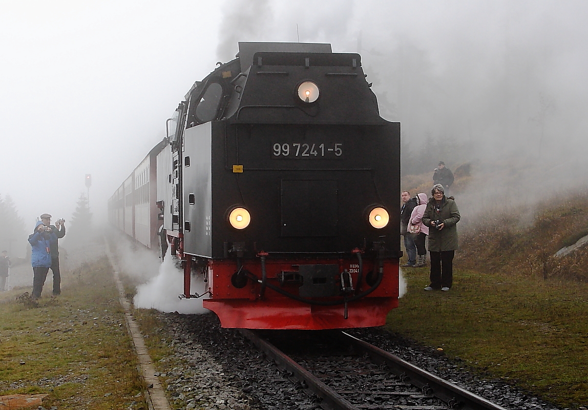 99 7241 mit P8944 in Richtung Drei Annen Hohne an der Ausweichstelle  Goetheweg  auf der Brockenstrecke. Sie hat das Tempo bereits erheblich gedrosselt, um ber die Weiche auf das Stichgleis fahren zu knnen, wo sich bereits 99 5901 mit einem Sonderzug der IG HSB (nicht im Bild) befindet. Nachdem der bergfahrende Zug P8923 die Stelle passiert hat, wird sie ihren Zug auf das Hauptgleis zurckdrcken und ihre Fahrt in Richtung Schierke fortsetzen, whrend der Sonderzug dann ebenfalls das Stichgleis verlt, um in Richtung Brocken weiterzudampfen. Eingerahmt wird die ganze Szenerie von zahlreichen Fahrgsten des Sonderzuges, welche (alle dick  eingepackt !) das Spektakel natrlich bildlich festhalten wollen!