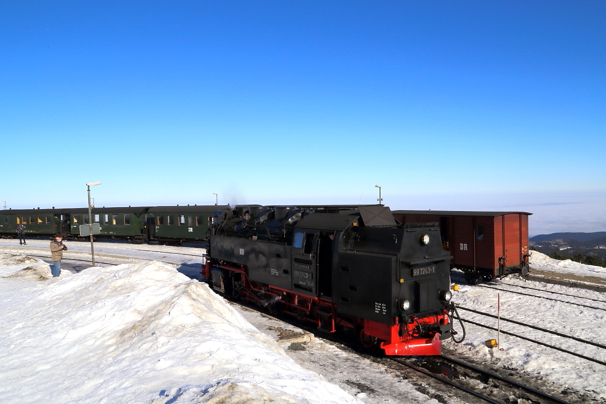 99 7243 am 13.02.2015 auf Rangierfahrt im Brockenbahnhof (Bild 1). Im Hintergrund steht der IG HSB-Sonderzug, welchen sie zuvor hierhergebracht hat und mit dem sie wenig später weiter nach Gernrode fahren wird.