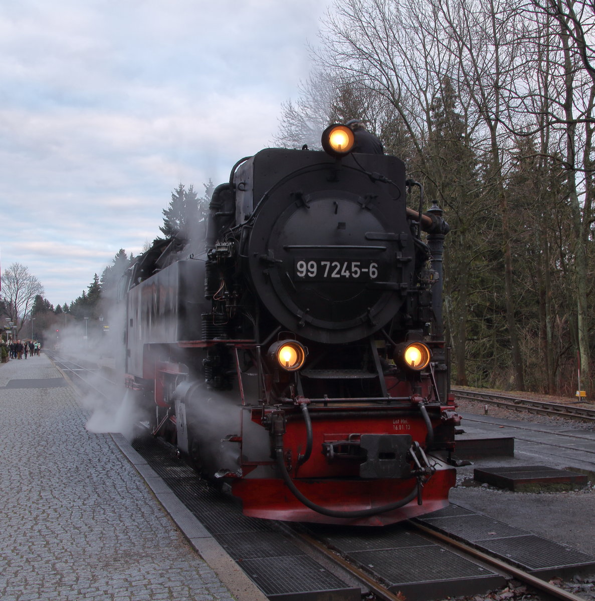 99 7245-6 ist mit P8914 (Eisfelder Talmühle - Wernigerode) in Drei Annen Hohne angekommen und hat sich zum Wasserfassen vom Zug getrennt. Gleich wird P8929 (Brocken - Nordhausen Nord) den Bahnhof erreichen, dessen Lok übernimmt den Zug nach Wernigerode und die hier zu sehende Lok fährt nach Nordhausen.

Drei Annen Hohne, 17. Dezember 2016