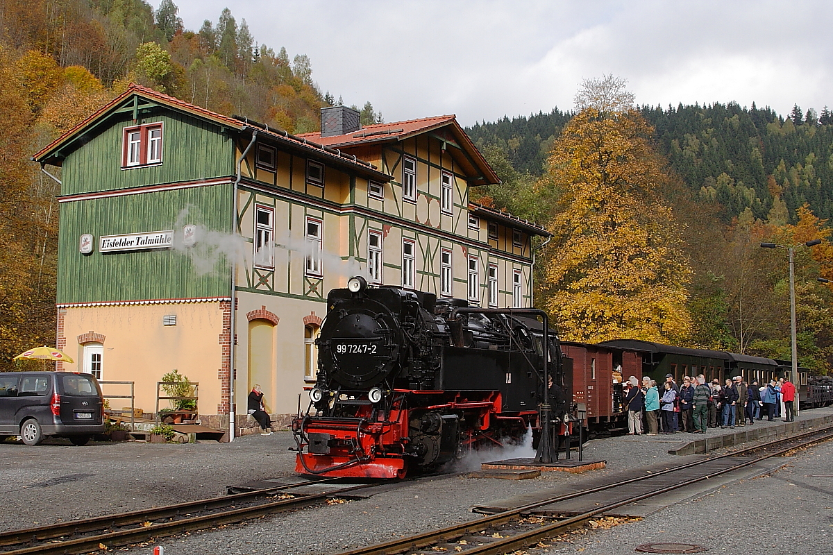 99 7247 mit einem Sonder-PmG der IG HSB am Haken, beim Wasserfassen am 20.10.2013 im Bahnhof  Eisfelder Talmühle . Dass so eine Dampfzugfahrt nicht nur großen Spaß, sondern auch hungrig und durstig macht, zeigt die lange Warteschlange der Zugfahrgäste am Verpflegungswagen, welche kurzentschlossen dem Vorbild der Lok folgten und ebenfalls eine Kleinigkeit zu sich nahmen! ;-)