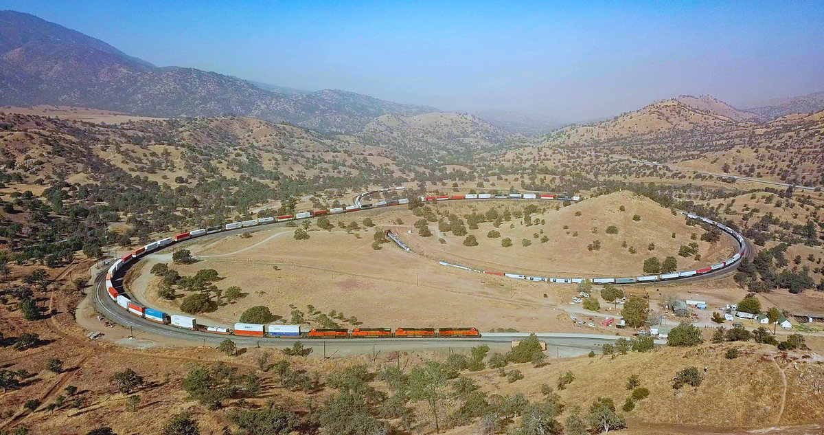 A BNSF freight train rounds the famous Tehachapi Loop.

The background is smokey due to wild fires...

*pic taken with a drone