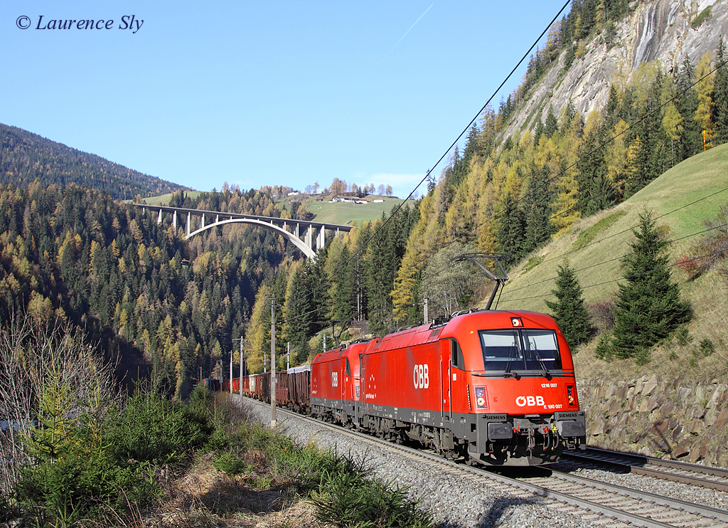 A pair of class 1216 locomotives (1216 007 leading) approach Sankt Jodok whilst working a southbound freight train, 8 November 2013.

The train is believed to be scrap from Hall in Tirol to Brescia Scalo.