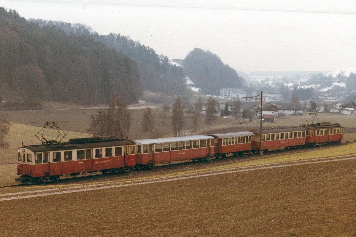 Aare Seeland Mobil/ASm/OJB.
Erinnererung an den ehemaligen Streckenabschnitt Langenthal-Melchnau.
Als Dank für die Kommentare zu meinen ASm Bilder der Bahnbildfotografen Rüdiger Ulrich, Stefan Wohlfahrt, Horst Lüdicke und Armin Schwarz stellte ich zwei weitere Aufnahmen vom ehemaligen Streckenabschnitt Langenthal-Melchnau ein. 
Betriebsaufnahme St. Urban Ziegelei-Melchnau 6.10.1917.
Einstellung Personenverkehr 22.5.1982.
Es ist sehr schade, dass die Züge aus dem Rottal verschwunden sind.
Leermaterialzug Melchnau-Langenthal bestehend aus BDe 4/4 4 + B4 17, ehemals BTB, + B2 11 + B4 20 + BDe 4/4 5 kurz vor Melchnau im Jahre 1979.
Zum Einsatz solcher Zugskompositionen kam es bei grossen Vereinsanlässen wie Musikfeste, Jugendriegetagen etc. die in Melchnau stattfanden.
Foto: Walter Ruetsch  