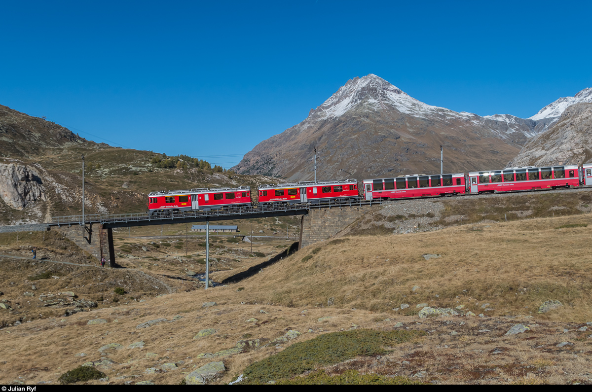 ABe 4/4 III 56  Corvigia  und ABe 4/4 III 55  Diavolezza  befinden sich am 16. Oktober 2016 mit einem Bernina-Express auf der Oberen Berninabachbrücke auf der Alp Bondo auf Talfahrt.