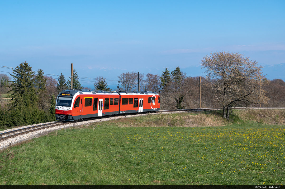 ABe 4/8 404-403 ist am 17.04.2021 auf der NStCM unterwegs und konnte hier vor dem Bahnhof Le Muids bei Arzier-Le Muids aufgenommen werden.