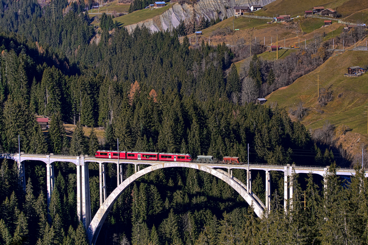 ABe 8/12 3501 fährt als R /Güterzug mit Sand und Kies beladen,von Chur nach Arosa über das Langwieserviadukt.Bild vom 18.11.2015
