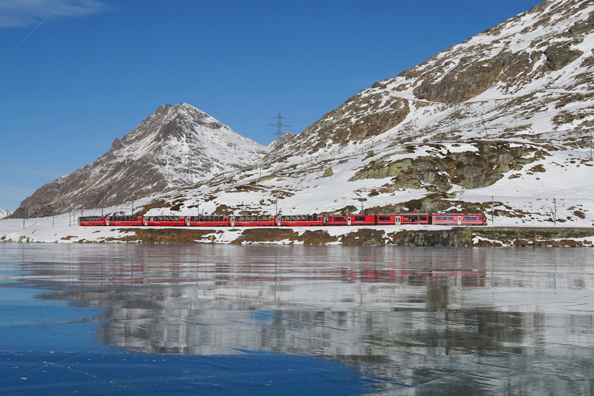 ABe 8/12 3504 zieht am 17.12.2016 den BEX 951 dem schwarz gefrorenen Lago Bianco entlang und erreicht in Kürze Ospizio Bernina.