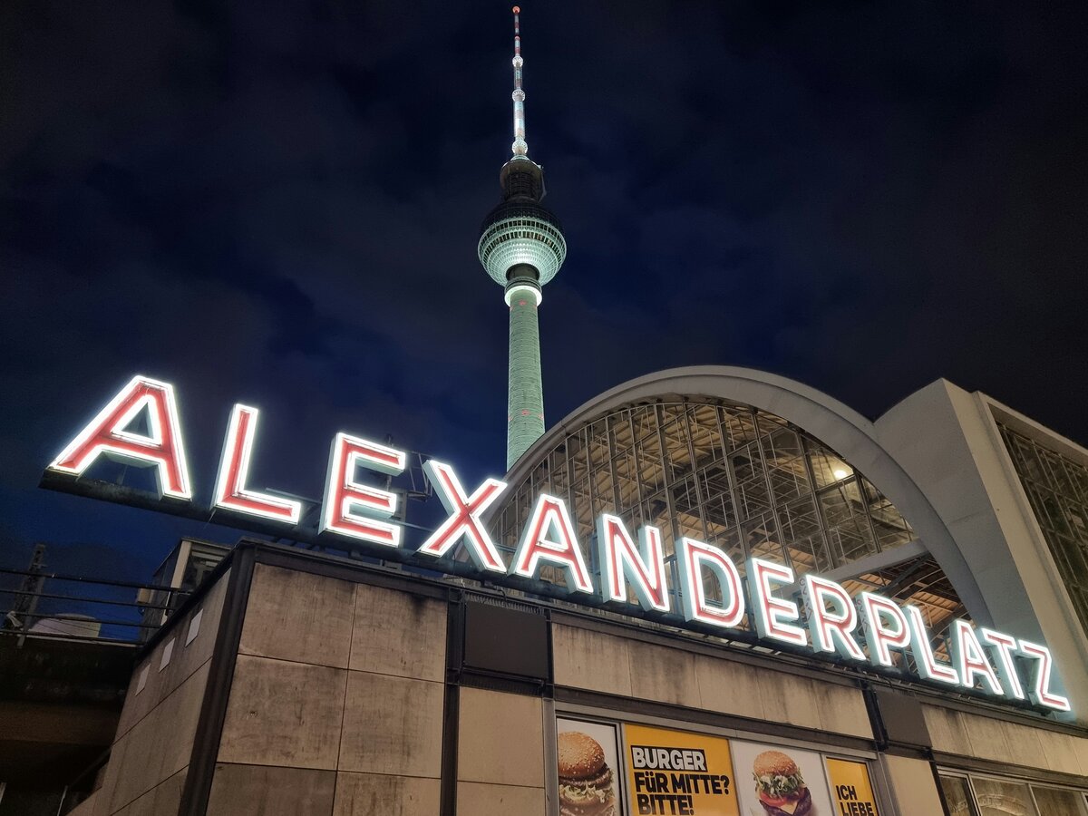 Abendliche Momentaufnahme am Bahnhof Alexanderplatz mit dem Fernsehturm, der Bahnhofshalle und dem passenden Schriftzug.

Berlin 17.02.2022