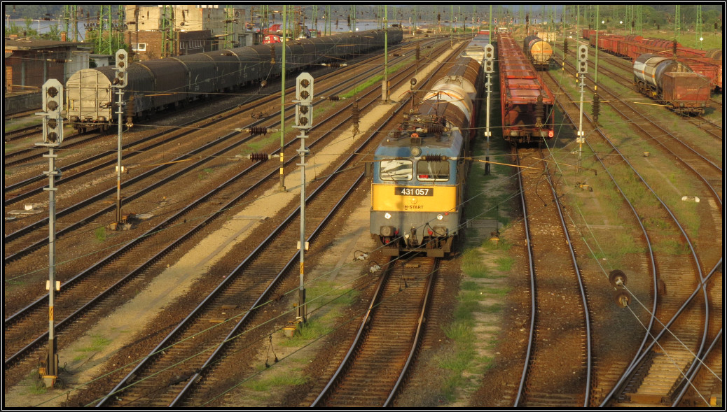 Abendstimmung am Bahnhof von Komárom. Die 431 057 (V43 der MAV) wartet mit ihren Güterzug auf die Ausfahrt nach Györ. Szenario vom 05.August 2015.