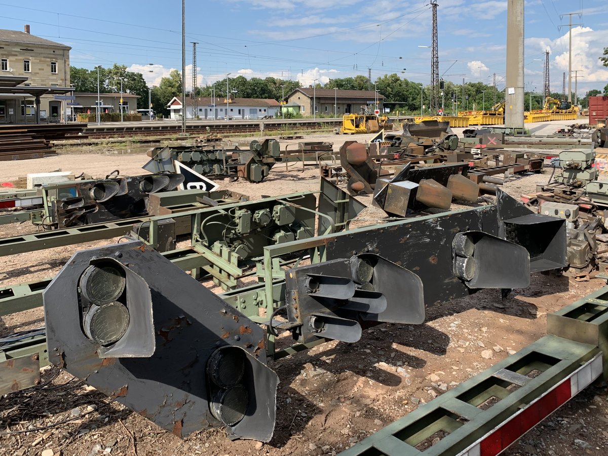 Abgebaute H/V-Signale am Bahnhof Neustadt a.d.Aisch.
Am 21.06.2020 wurde das 1968 in Betrieb genommene Relais-Stellwerk in Neustadt vom Netz genommen und durch ein ESTW ersetzt. 
Daher fielen auch alle alten H/V-Signale des Abschnitts Neustadt bis Markt Bibart den neuen Ks-Signalen zum Opfer.
Hier im Bild das alte ESig G, das mit einem Vorsignal, Ersatzsignal, Hauptsignal und elektrischem Geschwindigkeitsanzeiger ausgestattet war. Dieses stand bis dato an der Bahnstrecke Neustadt Aisch - Steinch zwischen Birkenfeld und Neustadt.
Die Bauaufsicht der Bahn hat mir dieses Signal freundlicherweise zur Verfügung gestellt und bekommt in meinem Garten nun eine zweite Heimat.