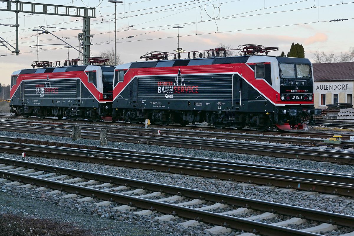 Abgestellt (||) - 143 124-6 und 143 056-0 der EBS Erfurter Bahnservice GmbH am 07.02.2022 in Aulendorf. Aufnahmestandort im Grnstreifen zwischen Strae und Gleise.