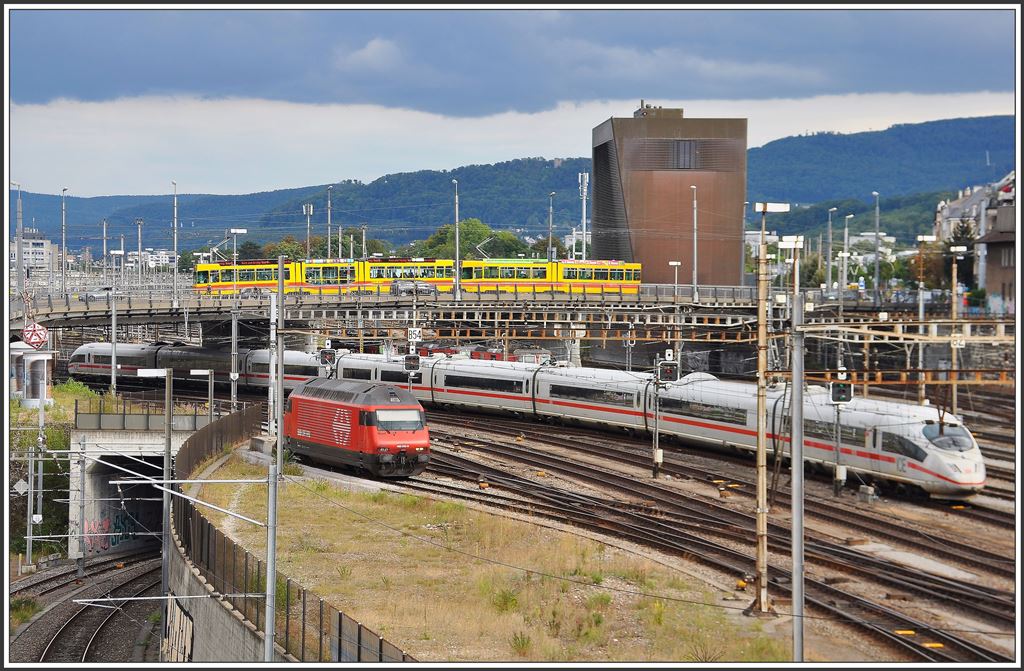 Abgestellte Re 460 vor nach Deutschland ausfahrendem ICE und vor dem Stellwerk ein Be 4/8 + Be 4/6 Gespann der BLT. (05.09.2015)