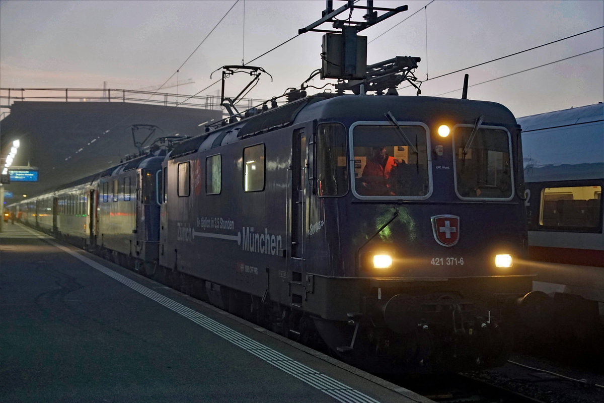 Abschied von den EC Zürich-HB  - München mit den Re 421 und den BR 218 sowie  dem alten Kopfbahnhof  Lindau vor dem Fahrplanwechsel vom 13. Dezember 2020.
Der Fahrplan 2021 bringt schnellere, häufigere und bequemere Verbindungen von Zürich-HB nach München. Die dunkelblauen Re 421 von SBB CARGO NATIONAL und die DB Diesellokomotiven der BR 218 werden nicht mehr gebraucht.  Auch der Lokwechsel im alten Kopfbahnhof Lindau mit dem schmucken Gebäude ist  bereits ab dem heutigen Sonntag Geschichte, da die Insel mit mit den direkten Zügen nach München nicht mehr angefahren wird.
Für einen kurzen Rückblick auf diese herrlichen Momente drehe ich das Rad der Zeit noch einmal für drei Bahnbildserien zurück.
Sämtliche Aufnahmen  sind während meiner Abschiedsfahrt vom 18. November 2020 entstanden. Da es sich um meine letzte Fahrt handelte und die Aufnahmen  inzwischen  bereits historisch sind, habe ich mir ausnahmsweise  erlaubt,  auch der nächtliche Beginn dieser für mich sehr speziellen Reise in Zürich-HB zu zeigen.

EC mit Doppeltraktion Re 421 371 und Re 421 383-3 Kurze Zeit vor der Abfahrt in Zürich-HB.
Foto: Walter Ruetsch

   
