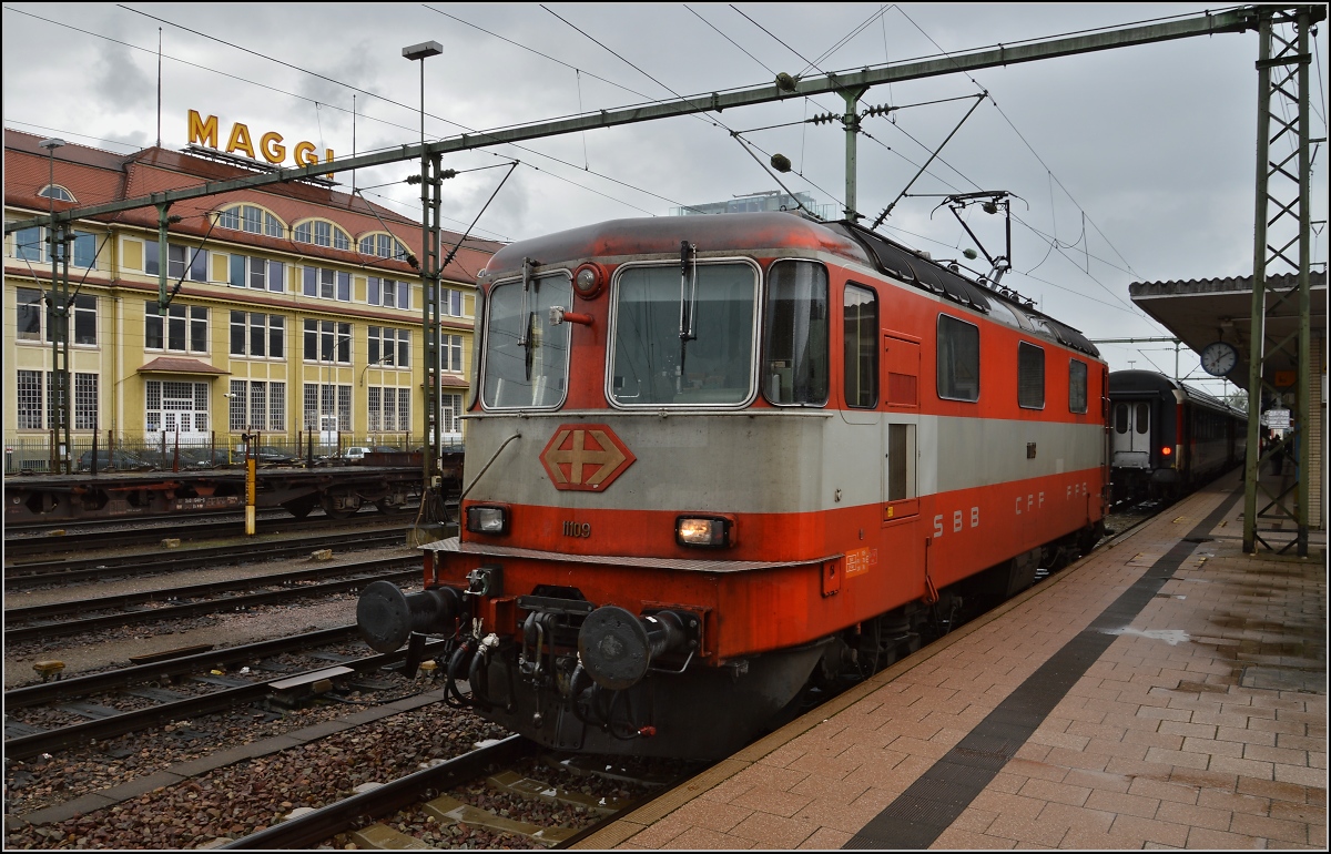 Abwechslung in Singen. Re 4/4<sup>II</sup> 11109 im schicken Swiss-Express-Design macht sich gut vor dem Maggi-Werk. August 2014.