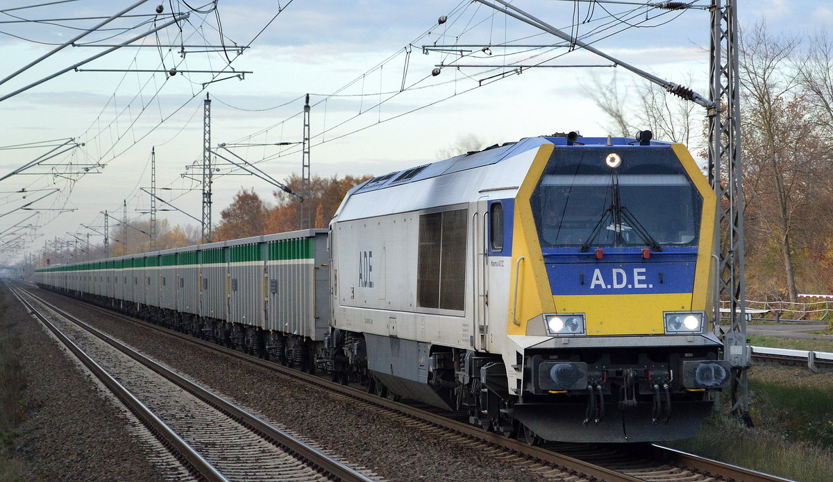 A.D.E. mit 264 007-6 (92 80 1264 007-6 D-ADE) mit ihrem Ganzzug offener Drehgestell-Güterwagen am 12.11.18 Bf. Berlin-Hohenschönhausen. 