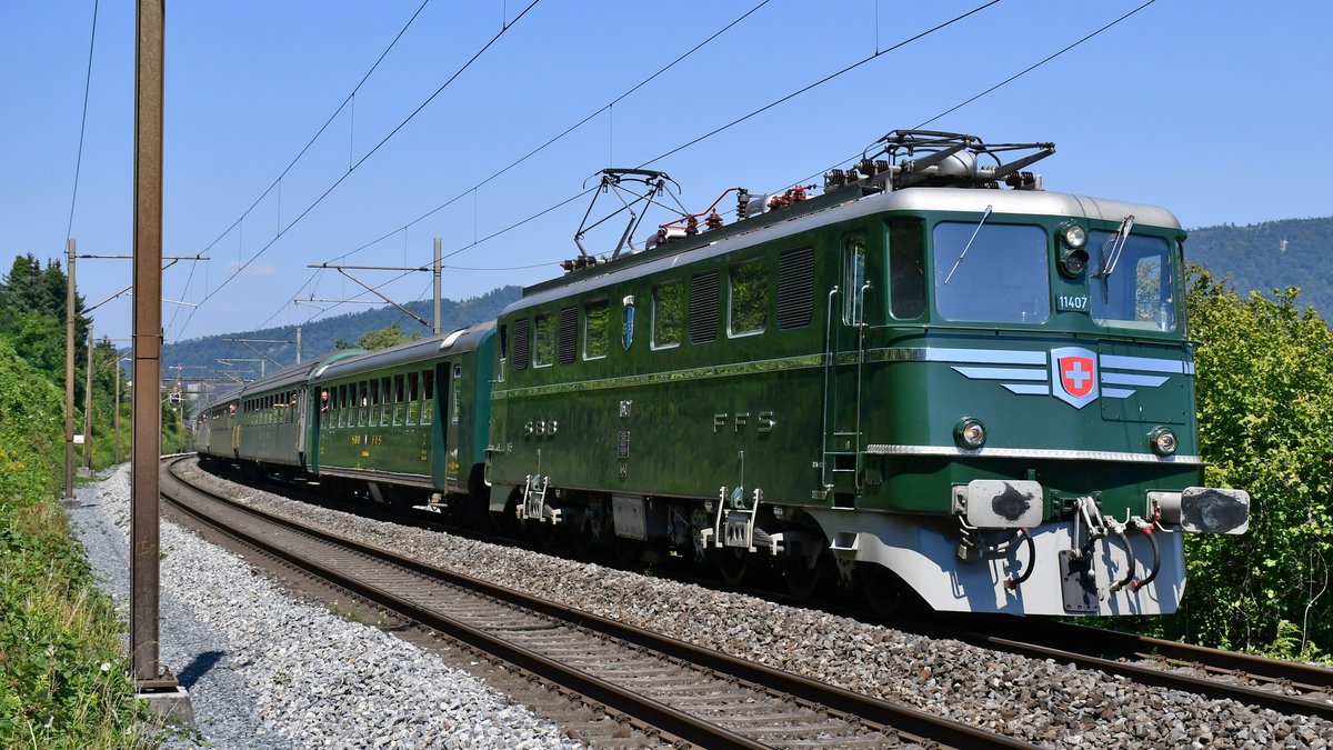 Ae 6/6 11407  Aargau  auf dem Weg nach Zürich HB mit dem Zürichsee-Express samt Dampflok 141.R.1244 am Haken, aufgenommen zwischen Neuenhof und Killwangen am 09.08.2020.