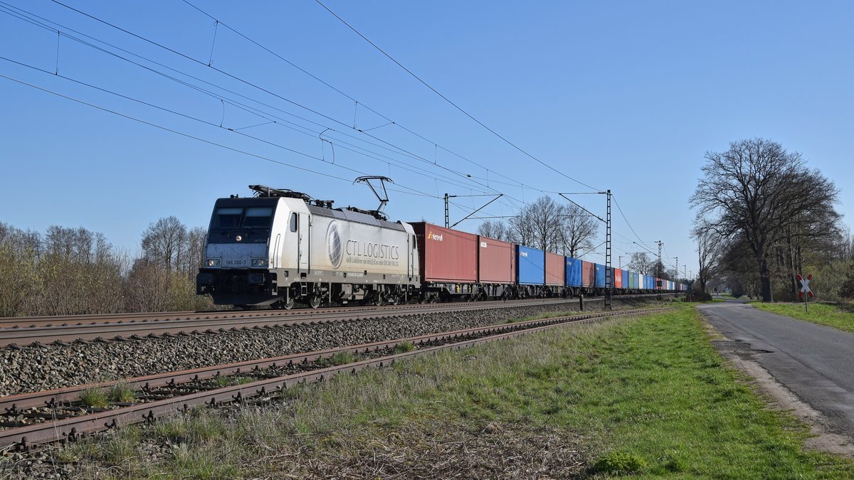 Akiem 186 266, vermietet an CTL Logistics, mit Containerzug in Richtung Bremen (bei Diepholz, 01.04.19).