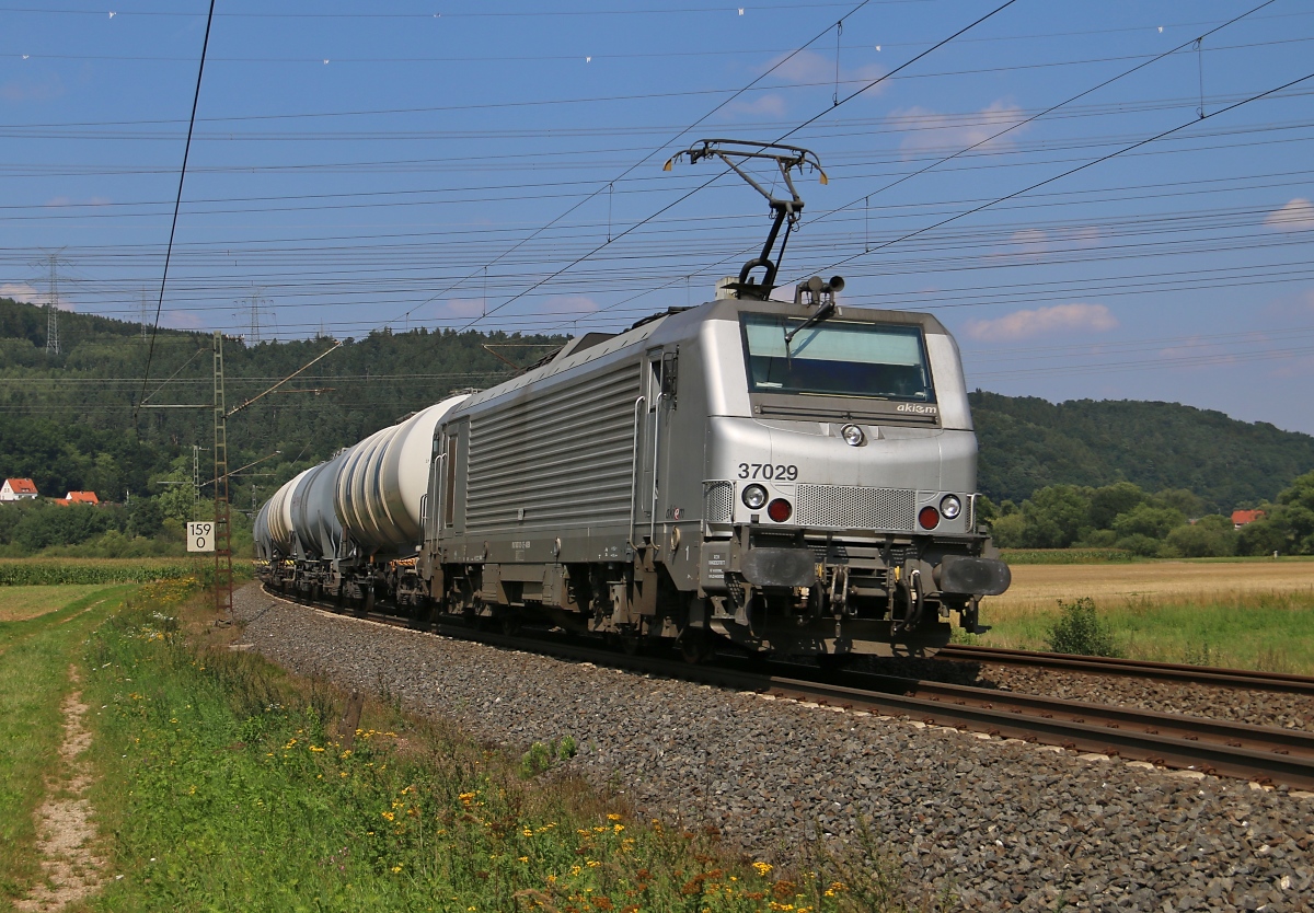 Akiem 37029 mit Kesselwagenzug in Fahrtrichtung Süden. Aufgenommen am 23.08.2015 zwischen Ludwigsau-Friedlos und Mecklar.