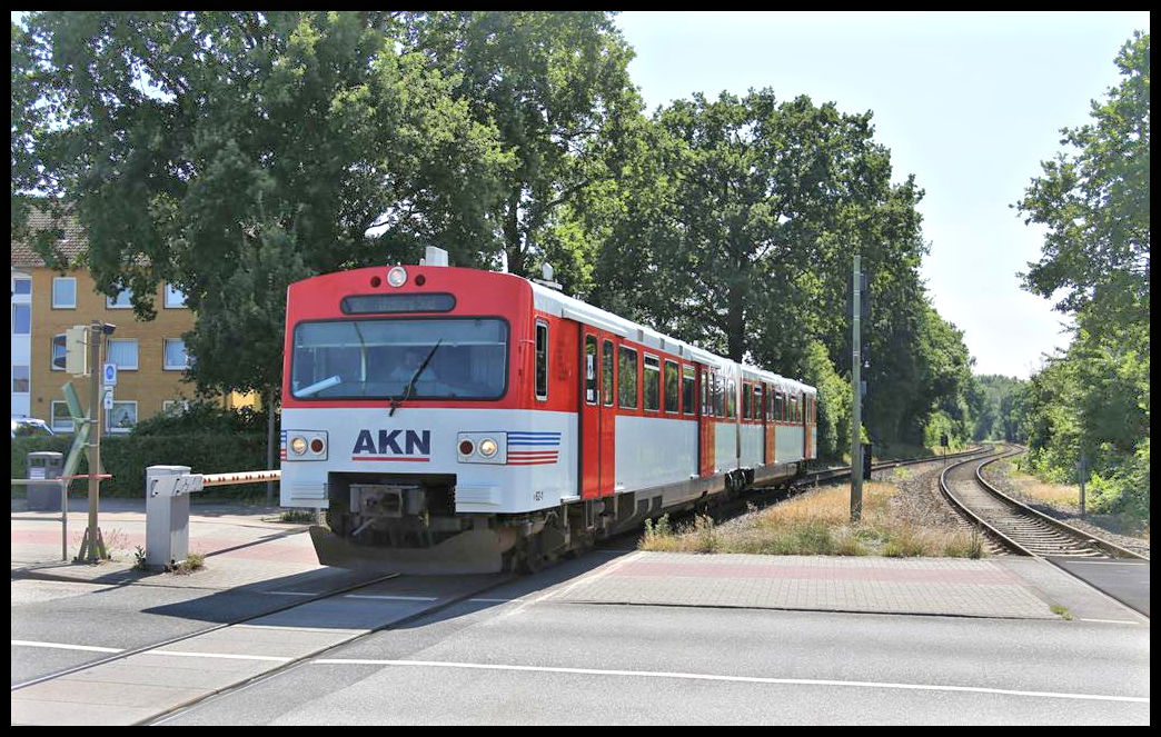 AKN Triebwagen 62.2 überquert hier am 24.07.2021 um 14.24 Uhr in Fahrtrichtung Kaltenkirchen die Quickborner Straße in Norderstedt, um direkt dahinter an dem gleichnamigen S-Bahnhof zu halten.