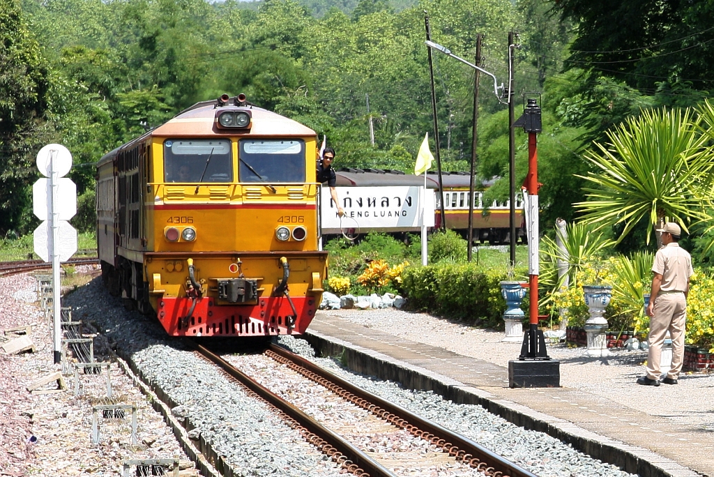 ALD 4305 (Co'Co', de, Alsthom, Bj.1983) fährt am 20.Mai 2018 mit RAP 102 (Chiang Mai - Bangkok) durch die Kaeng Luang Station. Der Beimann hält den Token des zurückgelegten Streckenabschnittes bereit, um ihn an den Halter (rot-weiss-rote Säule) am Bahnsteiganfang abzugeben.