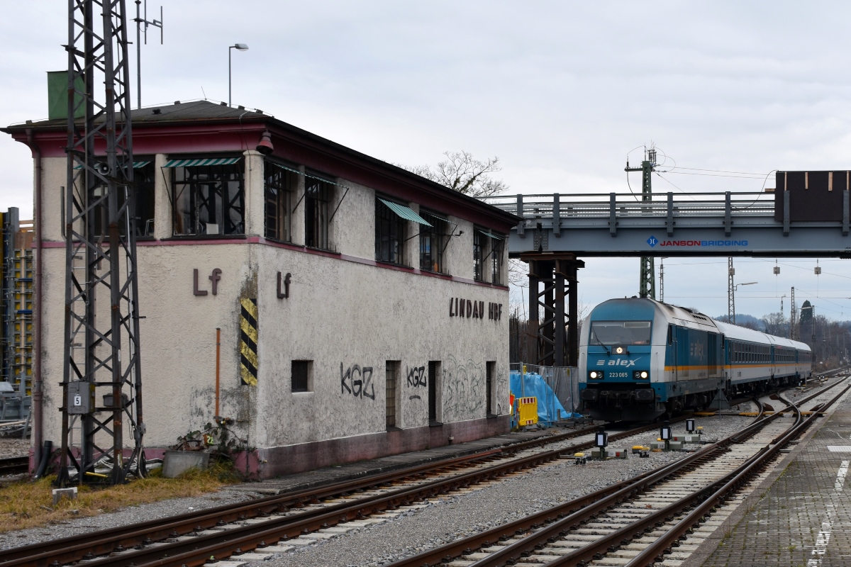 ALEX 223 065 erreicht mit ALX84138 von München kommend den Bahnhof Lindau. Die Lok befindet sich unter der einspurigen Behelfsbrücke über das Bahnhofsareal zum Inselparkplatz (als provisorischer Ersatz für die aus dem Jahr 1901 stammende Thierschbrücke bis zur Fertigstellung des Neubaus) (28.01.2018).