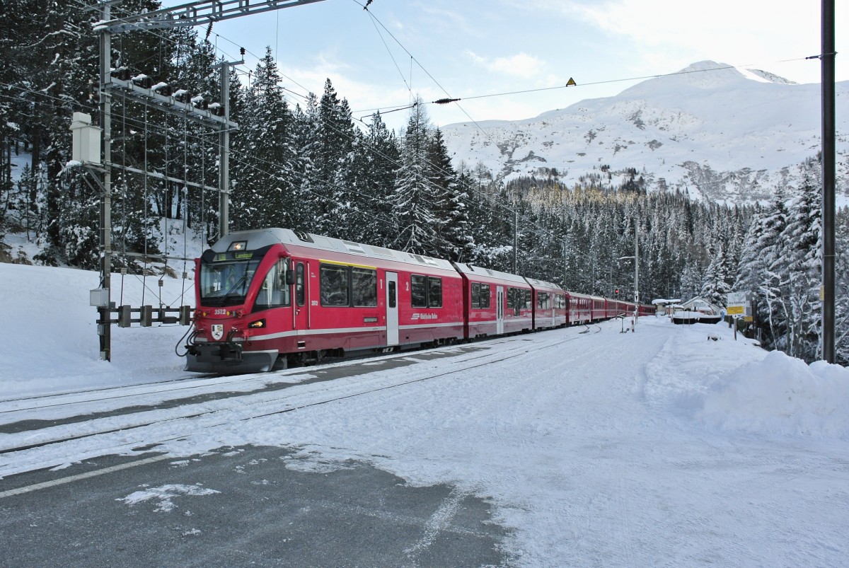 Allegra ABe 8/12 3512 mit dem RE 1028 in Davos Wolfgang. An erster Stelle hinter dem Triebzug ist der umgebaute/revidierte BDt 1722 eingereiht, dahinter sind noch 7 Personenwagen, 31.12.2013.