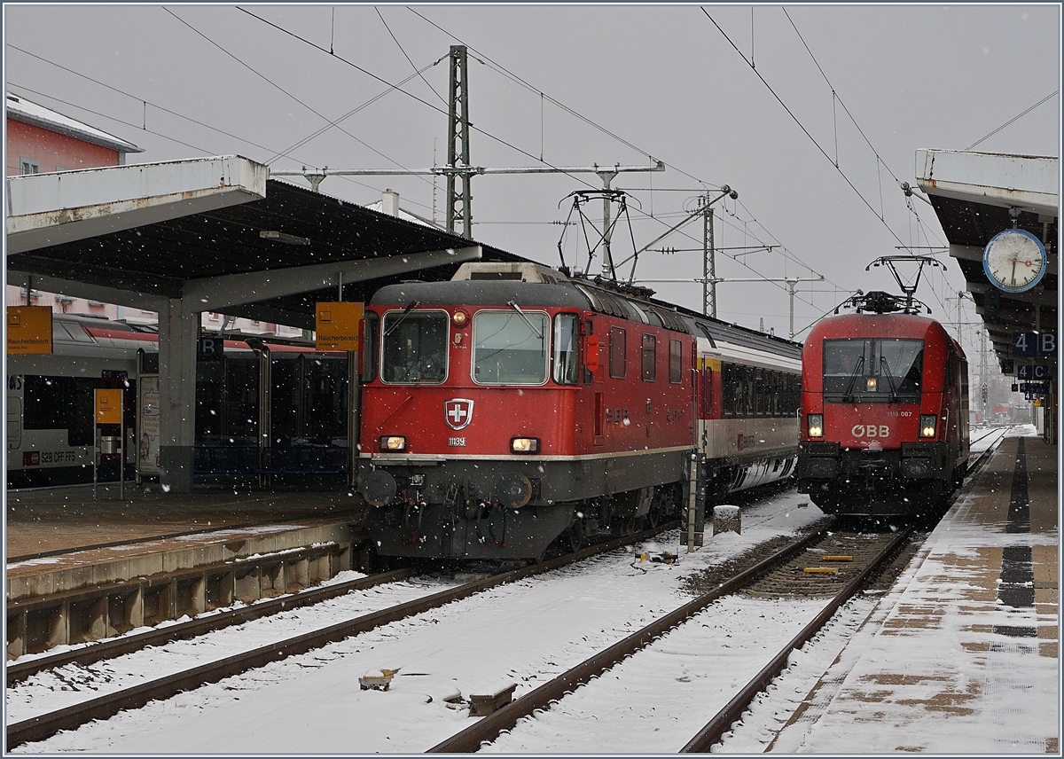 Alpenbahnloks im Flachland: Während die ÖBB 1116 087 den IC von Stuttgart nach Singen brachte und nun auf die Rückleistung wartet, hat die SBB Re 4/4 II 11139 den Zug übernommen und wird in nach Zürich führen. 
Singen, den 9. Dez. 2017