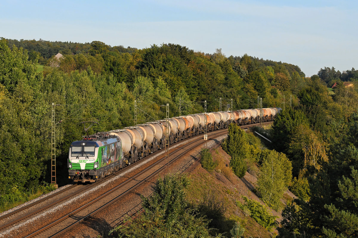 Alpenländische Motive zeigt die an die SETG vermietete 193 839 von ELL. Am Abend des 19. September 2020 bildete der farbenfrohe Vectron den überraschenden Abschluss eines abwechslungsreichen Ausfluges an die KBS 880. Mit einem Ganzzug bestehend aus Knickkeselwagen zur Beförderung von Kreideschlamm konnte die Maschine im warmen Abendlicht auf der Stützmauer bei Laaber in der Oberpfalz fotografiert werden.