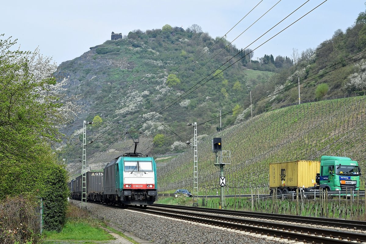 Alpha Trains Belgium E 186 210, vermietet an Crossrail Benelux, ist mit einem Containerzug am 12.04.18 unterhalb der Burgruine Hammerstein bei Leutesdorf in Richtung Neuwied unterwegs. 