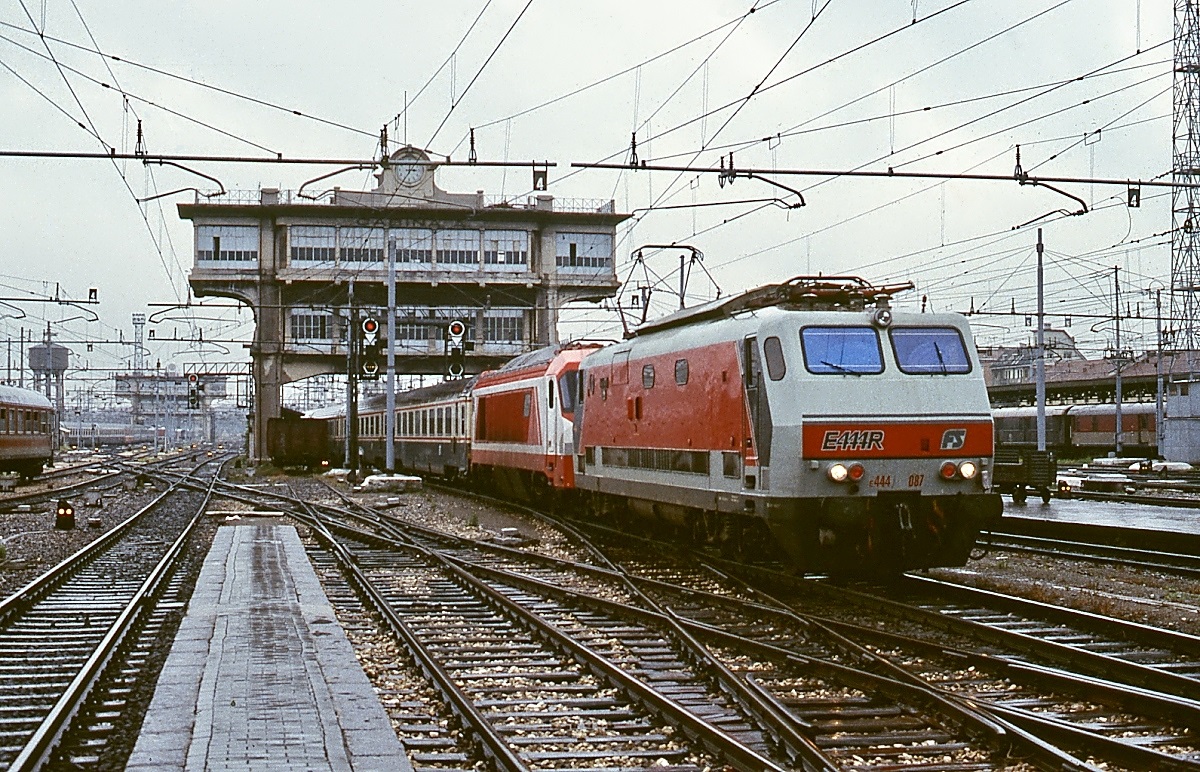 Als E 444 087 (mit einer E 402A im Schlepp) im April 1986 in Milano Centrale einfährt, hat sie bereits den kastenförmigen Führerstand, den die Lokomotiven zwischen 1989 und 1997 erhielten. Dadurch haben sich zwar die Arbeitsbedingungen für die Lokführer verbessert, die Lokomotiven wurden m. E. aber ihrer Eleganz beraubt.