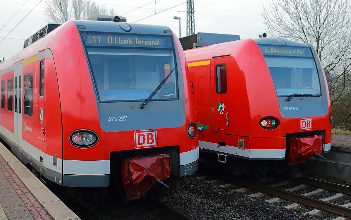 Als Falschfahrt überholt 425 579-0 mit dem RE 6a den defekten 423 297 am 11.03.2016 in Nievenheim, der auf dem Weg zum Düsseldorfer Flughafen hier liegengeblieben ist. Auf dem Bahnsteig warteten zahlreiche Berufstätige, Schüler und Reisende mit Gepäck seit geraumer Zeit auf die S 11. Die Informationspolitik der DB war desaströs: Zur planmäßigen Ankunftszeit um 08:10 Uhr kam die Durchsage, dass die Bahn etwa 5 Minuten später eintreffen würde. Bis 08:30 ereignete sich nichts, dann wurde mitgeteilt, dass die S 11 um 08:30 Uhr um etwa 5 Minuten verspätet sei. Etwa eine Viertelstunde später traf dieser Zug ein, den alle Reisenden verlassen mussten. Erst nachdem es gelungen war, den Zug in die Gleisanlage der Industriebahn Zons-Nievenheim zurückzusetzen, konnten die folgenden S-Bahnen ab etwa 09:00 Uhr die Fahrgäste weiter befördern.