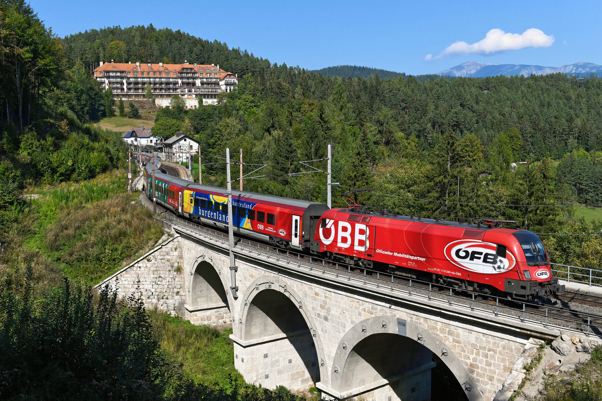 Als RJ 535 nach Villach war am 21. September 2020 die ÖFB Werbelok 1116.249 samt passender Wagengarnitur eingesetzt. Bei der Durchfahrt durch die Station Wolfsbergkogel konnte ich den bunten Zug fotografieren. Im Hintergrund ist das Kurhaus Semmering zu sehen, rechts davon das Bergmassiv der Rax. 
