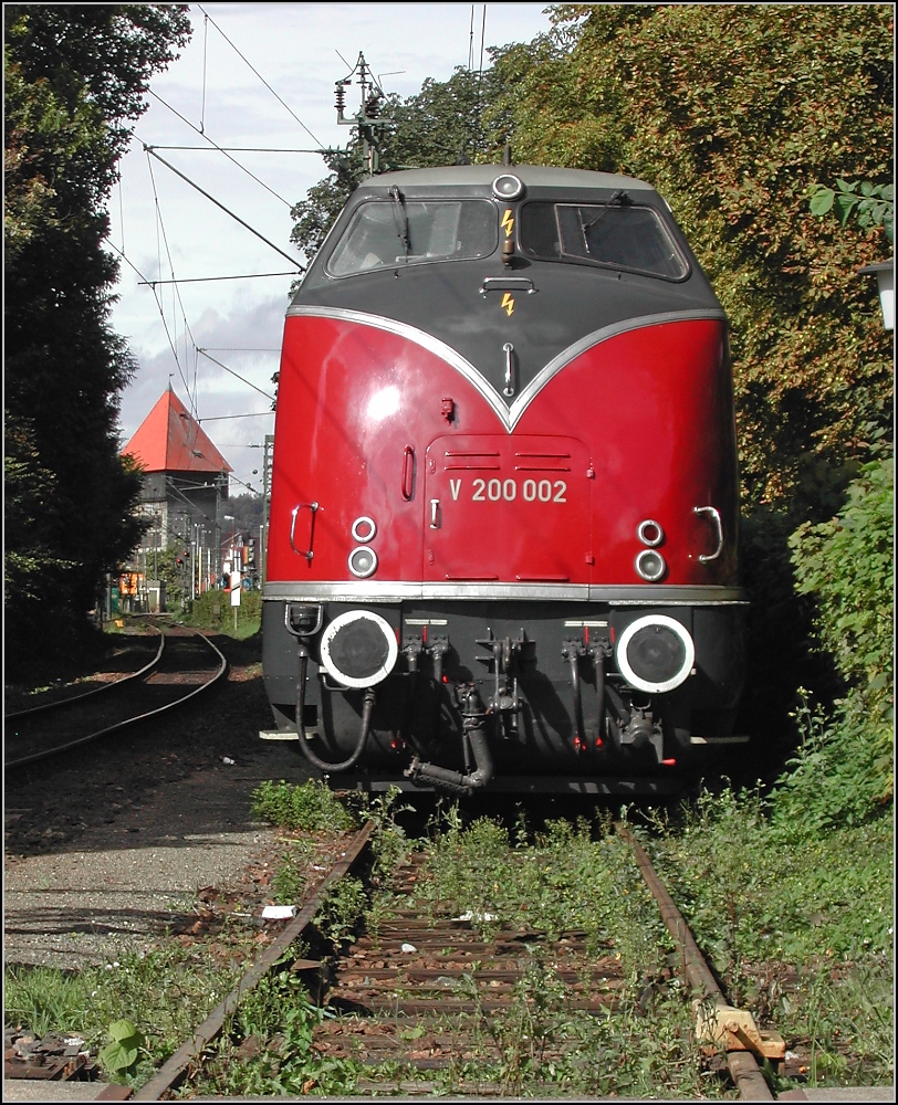 Als sie noch lebte. V200 002 glänzt wie eine Speckschwarte in der Sonne des 11. September 2005, geparkt auf dem Stumpengleis des Haupbahnhof Konstanz, zwischen Konzilsgebäude, Stadtgarten und altem Rathaus. Standort des Fotografen ist der Bahnübergang am Konzil, während der Überquerung Richtung Bahnhof. 