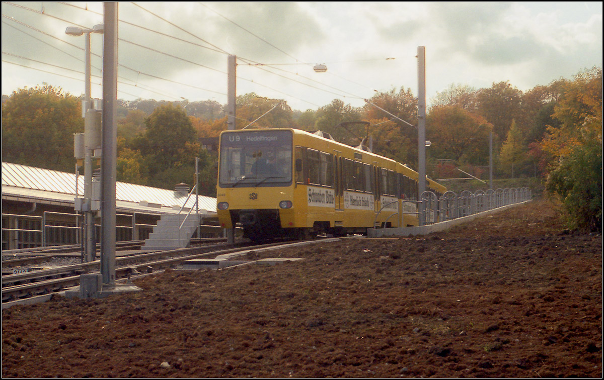 Als die Stadtbahn noch jung war -

Am 30. September 1989 wurde die Linie 9 auf dem Abschnitt Vogelsang - Hauptbahnhof -
Raitelsberg - Hedelfingen auf Stadtbahnbetrieb umgestellt. Zu diesem Zeitpunkt erhielten die Stadtbahnlinien auch das 'U' in der Linienbezeichnung.

Das Bild zeigt die Wendeanlage der U9 hinter der Haltestelle Vogelsang. Links daneben ist der ehemalige Straßenbahnbetriebshof erkennbar. Auf der rechten Seite befinden sich heute die Streckengleise der Linie U2 nach Botnang. 

1989 wollte man eigentlich gleich mit dem Weiterbau nach Botnang beginnen um 1991 oder 92 mit der Stadtbahn auch diesen Stadtteil zu erreichen. Dazu war ein Tunnel unter dem Botnanger Sattel notwendig. Als aber aufgrund der IGA '93 die Neubaustrecke zum Killesberg in Bau ging und die Zuschüsse gekürzt wurden, wurde der Tunnelbau unter dem Botnanger Sattel auf unbestimmte Zeit verschoben und es sah so aus, als ob es über einen sehr langen Zeitraum ein Mischbetrieb zwischen der Stadtbahnlinie U9 und der Straßenbahnlinie 4 geben würde, die weite Streckenteile gemeinsam befahren. Letztlich kam es doch schneller und die Linie 4 wurde dann 1994 auf Stadtbahnbetrieb umgestellt.

Scan vom Farbnegativ, 1989