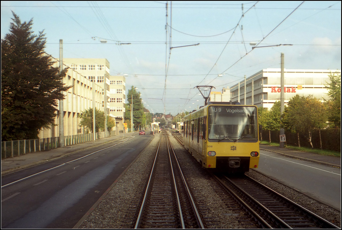 Als die Stuttgarter Stadtbahn noch jung war -

Blick aus der hinteren Plattform eines GT 4-Straßenbahnzuges der Linie 13 auf die Bahnkörperstrecke mit Dreischienengleis in der Hedelfinger Straße. Im Hintergrund die Haltestelle 'Kodak' (heute: 'Hedelfinger Straße', die von Beginn des Stadtbahnbetriebes mit Hochbahnsteigen ausgerüstet war, neben den Tiefbahnsteigen für die Straßenbahnlinie 13.

Scan vom Farbnegativ, 1989